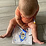 Jaden is registered to the contest to win money with this photo: baby, child, coloring, marker, floor, tile, onesie, cartoon, art, drawing, sitting, toes, bald, striped_clothing, hand, paper, messy, play, indoor, creativity