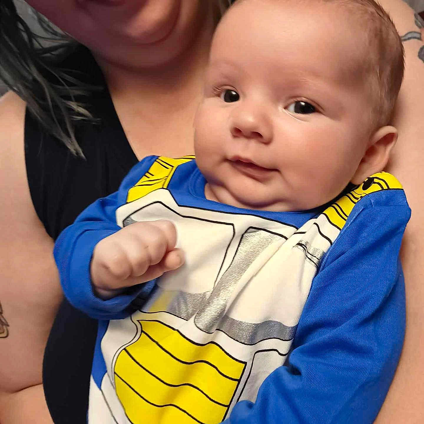 Morgan is registered to the contest to win money with this photo: adult, arm, baby, blue, child, closeup, clothing, face, family, glasses, happy, head, holding, indoor, person, portrait, skin, smiling, tattoo, yellow