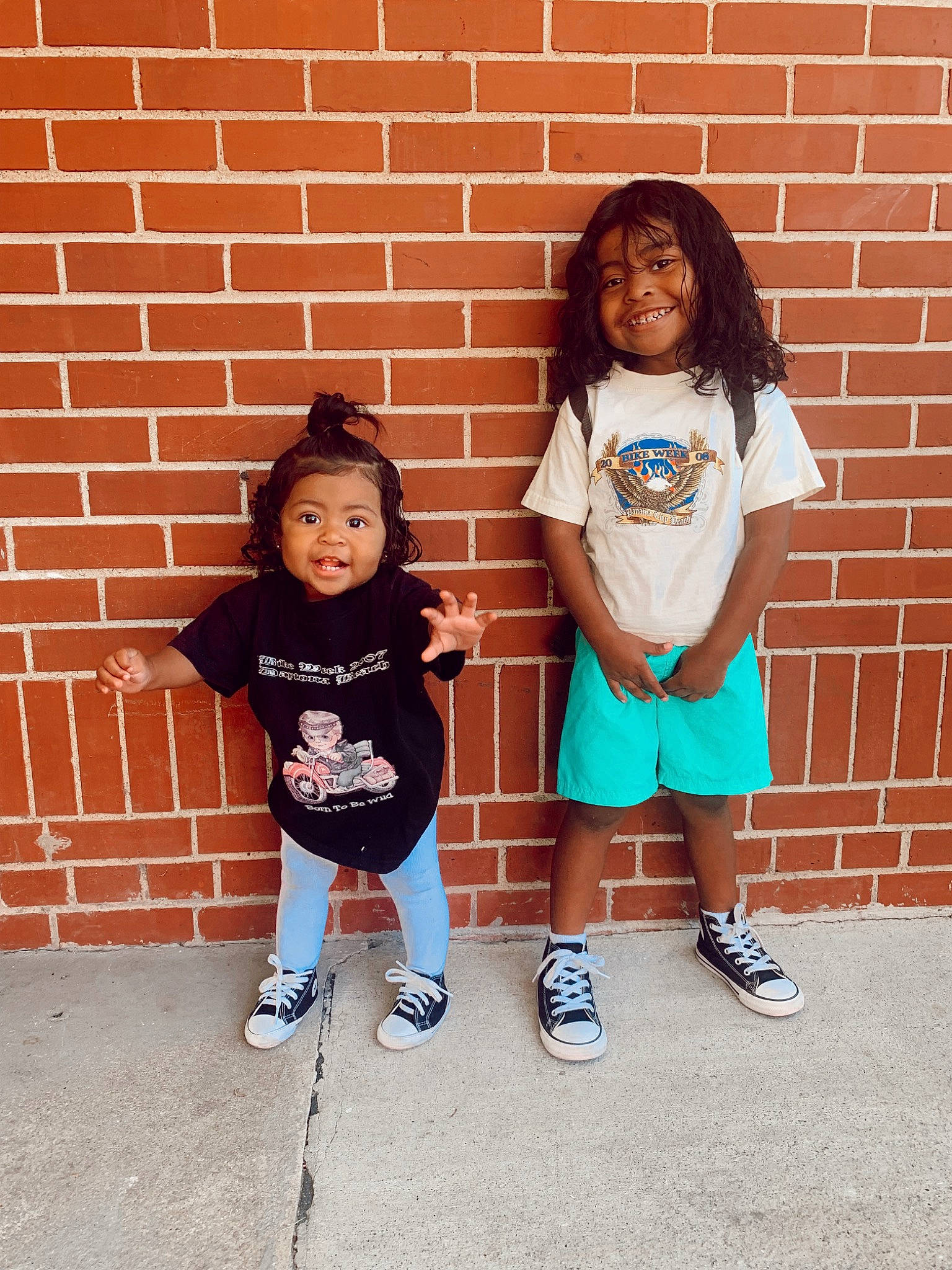 Nila is registered to the contest to win money with this photo: brick, brickwork, cool, footwear, fun, gesture, hair, hairstyle, happy, joy, leg, person, pink, shoe, shorts, sleeve, smile, sneakers, standing, t_shirt