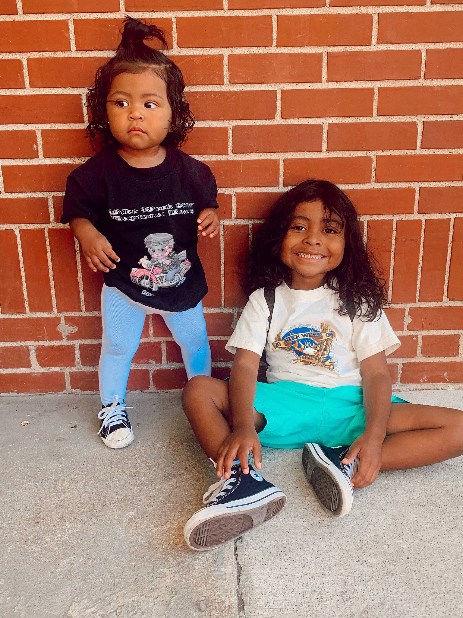 Isiah is registered to the contest to win money with this photo: brick, cool, facial_expression, footwear, hair, happy, headwear, joint, joy, knee, leg, people, person, pink, shoe, shorts, skin, sneakers, standing, t_shirt