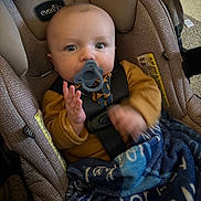Taylor is registered to the contest to win money with this photo: baby, pacifier, car_seat, blanket, child, infant, seatbelt, blue, brown_clothing, indoor, car_seat_strap, soft_texture, toddler, person, cute, young_child, sitting, face, hands, closeup