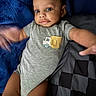 baby, infant, onesie, gray_clothing, blue_blanket, checkered_blanket, smiling, face, arms, legs, bed, soft_texture, motion_blur, cute, young_child, portrait, indoors, happy, person, child