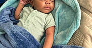 Ezari is registered to the contest to win money with this photo: baby, sleeping, blanket, soft_texture, infant, cozy, child, bed, resting, cute, peaceful, wrapped, clothing, hand, face, indoors, comfort, nap, toddler, fabric