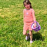 child, girl, grass, outdoor, sunny, pink_clothing, shorts, tank_top, purple_shoes, bucket, nature, greenery, casual, summer, portrait, young, playful, standing, field, daylight
