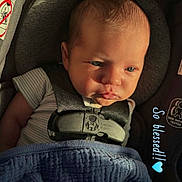 Gunner is registered to the contest to win money with this photo: baby, infant, car_seat, blanket, sunlight, blue_blanket, straps, child, face, expression, sitting, closeup, indoors, clothing, safety_harness, cute, newborn, portrait, peaceful, baby_boy