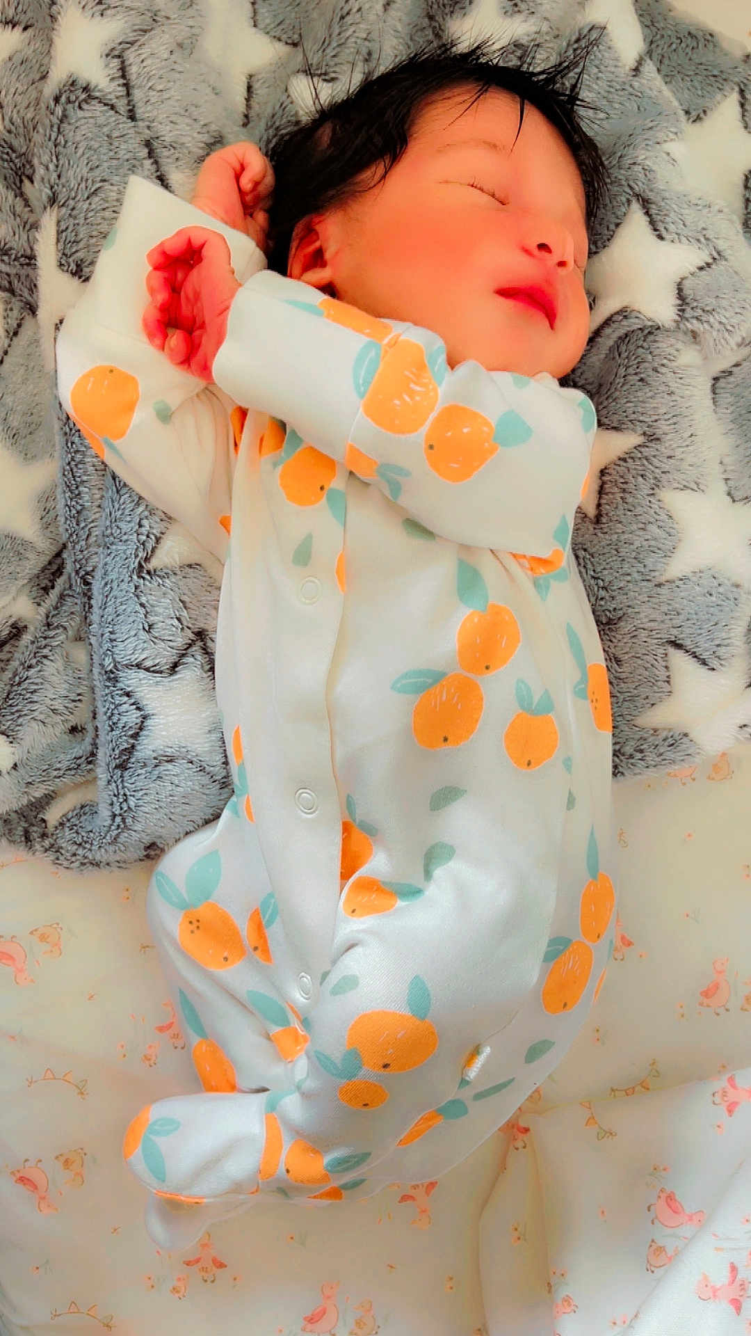 Nysha is registered to the contest to win money with this photo: newborn, baby, sleeping, onesie, orange_pattern, blanket, star_pattern, infant, cute, soft_texture, peaceful, hands, face, lying_down, cozy, child, bed, resting, clothing, portrait
