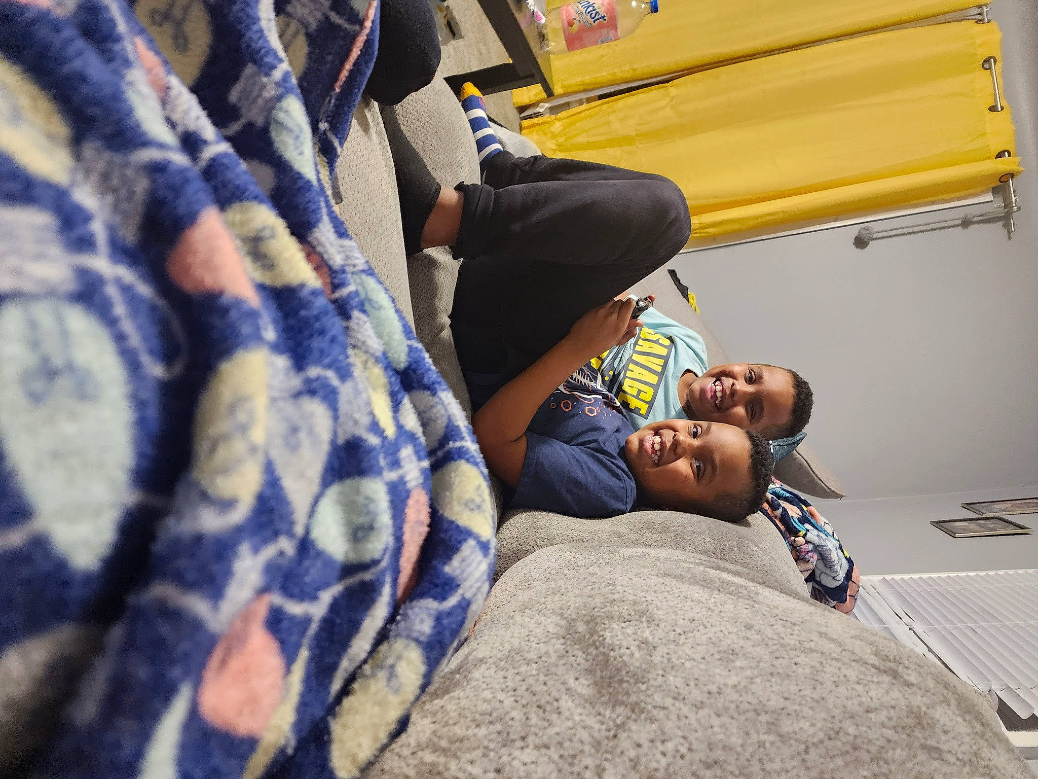 Elijah is registered to the contest to win money with this photo: child, comfort, elbow, fun, human_leg, joy, knee, leg, leisure, linens, nap, person, public_transport, room, sitting, t_shirt, thigh, toddler