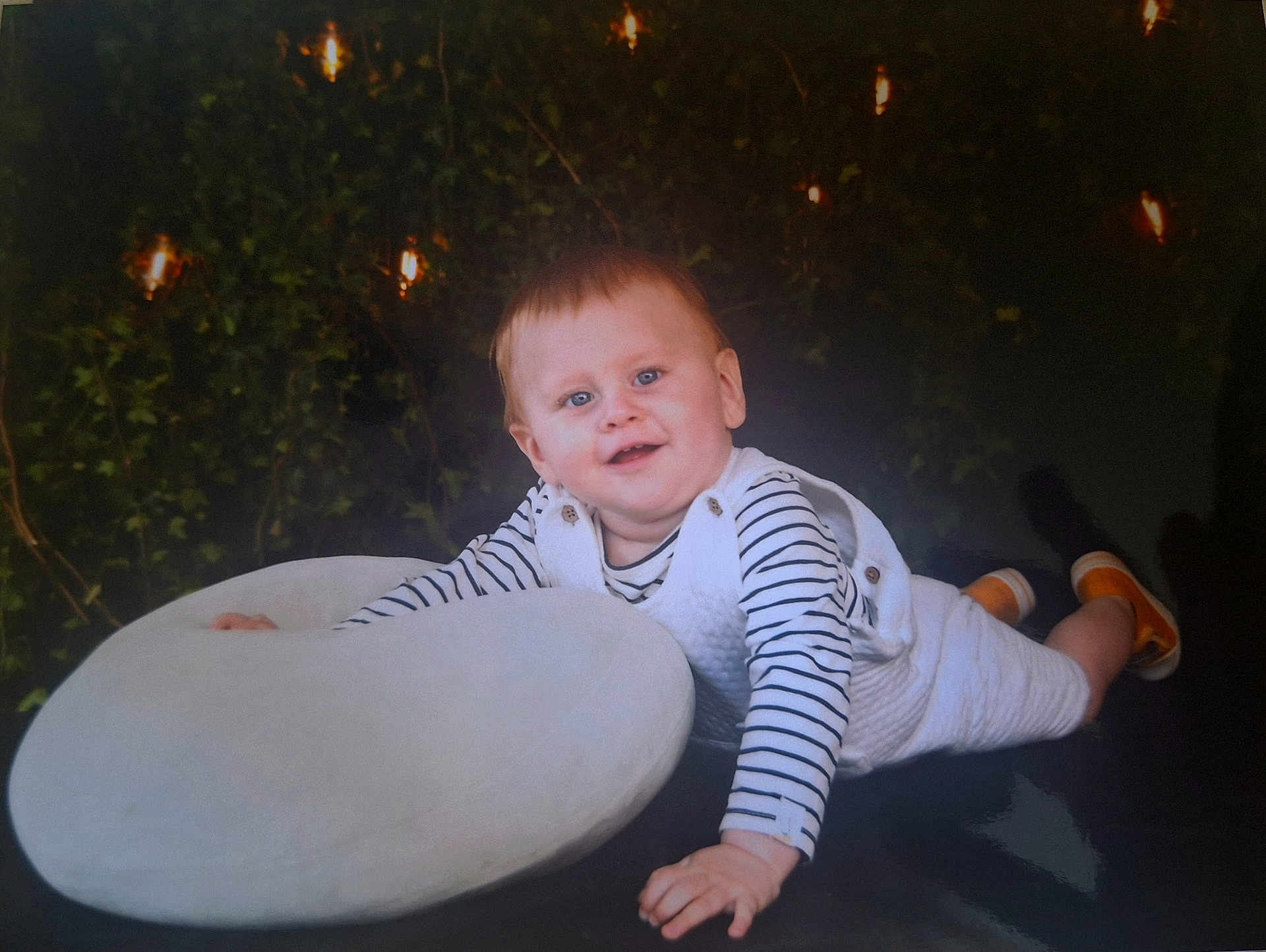 Noa a rejoint le concours — aidez-le/la à gagner de superbes lots ! baby, bodypart, clothing, cushion, cutlery, face, finger, footwear, frisbee, head, homedecor, lighting, pants, person, photography, plant, portrait, pottedplant, shoe, toy