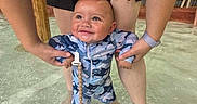 Jaxson joined the competition — help win amazing prizes! baby, child, infant, smiling, water, pool, swimming, outdoor, adult, supervision, portrait, face, happy, clothing, camouflage, pacifier, shallow_water, summer, family, playtime