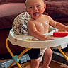 Jaxson joined the competition — help win amazing prizes! baby, child, infant, smiling, tongue_out, seated, baby_walker, tray, snack, food, couch, indoors, portrait, bare_chested, barefoot, wooden_floor, playtime, happy, home, photography