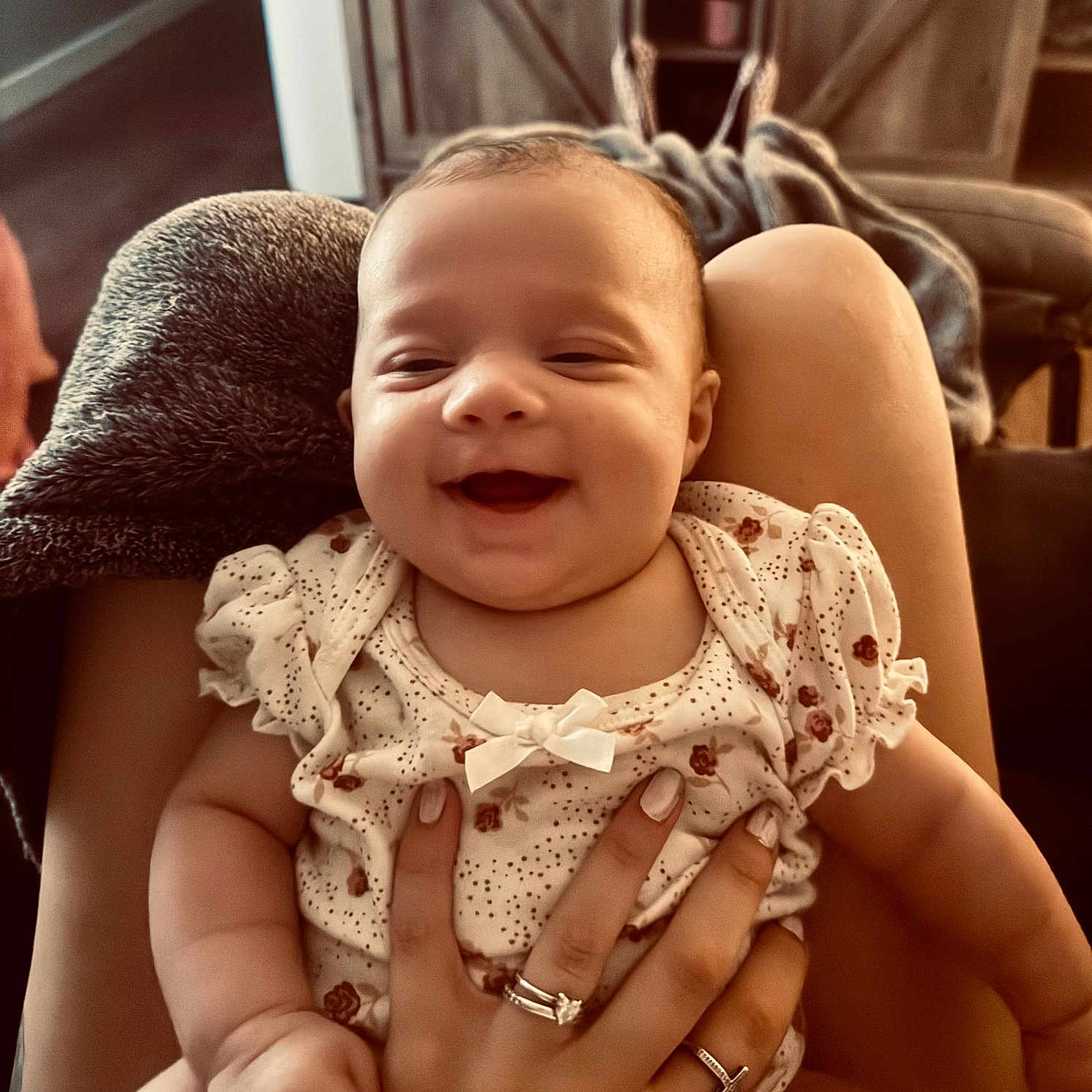 Tenley Kate is registered to the contest to win money with this photo: baby, blanket, clothing, cozy, cute, face, furniture, hand, happy, holding, home, indoor, infant, lap, person, rings, sitting, skin, smile, warm_light