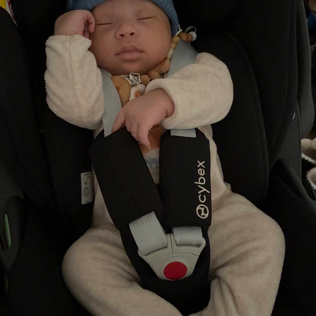 Tidiani participe au concours pour gagner de l'argent avec cette photo : baby, baby_accessory, black_car_seat, blue_hat, car_seat, child, cozy_clothing, cute, headwear, indoors, infant, newborn, peaceful, resting, safety, seatbelt, sleeping, soft_fabric, straps, toddler