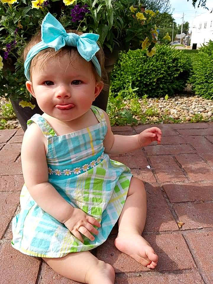 Fraya is registered to the contest to win money with this photo: baby_toddler_clothing, botany, child, clothing, dress, face, fun, grass, green, hairstyle, happy, head, headwear, joy, leaf, person, pink, plant, skin, sleeve