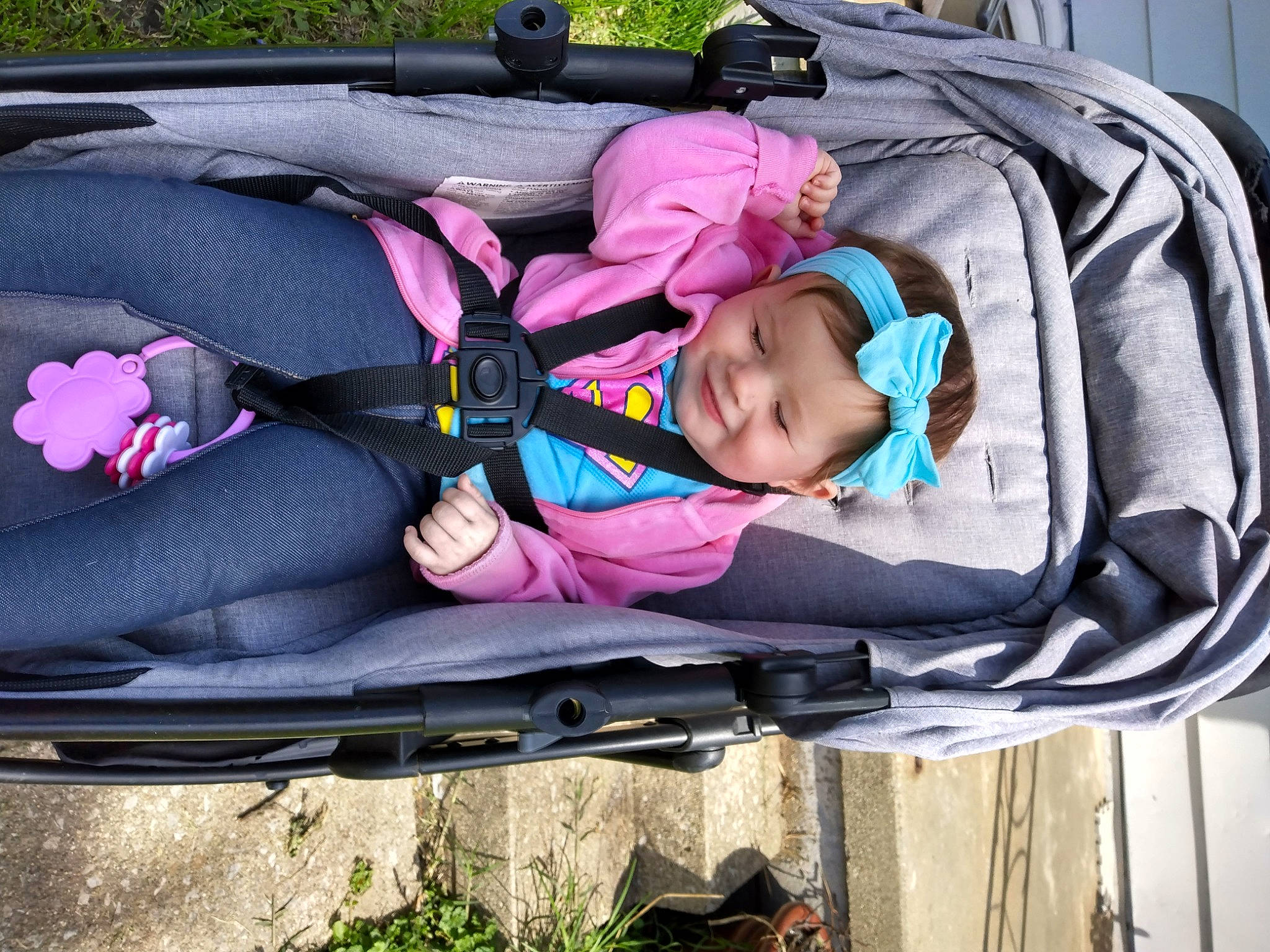 Fraya is registered to the contest to win money with this photo: auto_part, baby, baby_carriage, baby_products, baby_toddler_clothing, car_seat, child, comfort, family_car, grass, headwear, joy, lap, leisure, luggage_and_bags, person, pink, plant, recreation, shoe