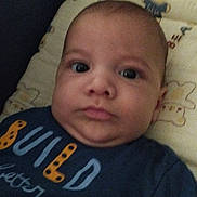 Adem a rejoint le concours — aidez-le/la à gagner de superbes lots ! baby, infant, face, portrait, cushion, teddy_bear, clothing, blue_shirt, text_on_clothing, lying_down, indoors, child, cute, young, skin, head, expression, person, closeup, soft_toys