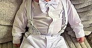 Jamie is registered to the contest to win money with this photo: baby, bow_tie, child, comfortable, couch, cute, fashion, footwear, gray_couch, indoors, infant, person, portrait, shoes, sitting, soft_fabric, suspenders, texture, white_clothing, young