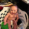 Parker is registered to the contest to win money with this photo: baby, child, laundry_basket, smile, indoor, blanket, pillow, diaper, happy, cute, furniture, toy, face, skin, person, seated, home, comfort, playful, infant