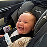 baby, car_seat, child, smiling, happy, infant, seatbelt, clothing, safety, vehicle, interior, face, person, cute, portrait, young_child, car_window, fabric, seat, baby_clothes