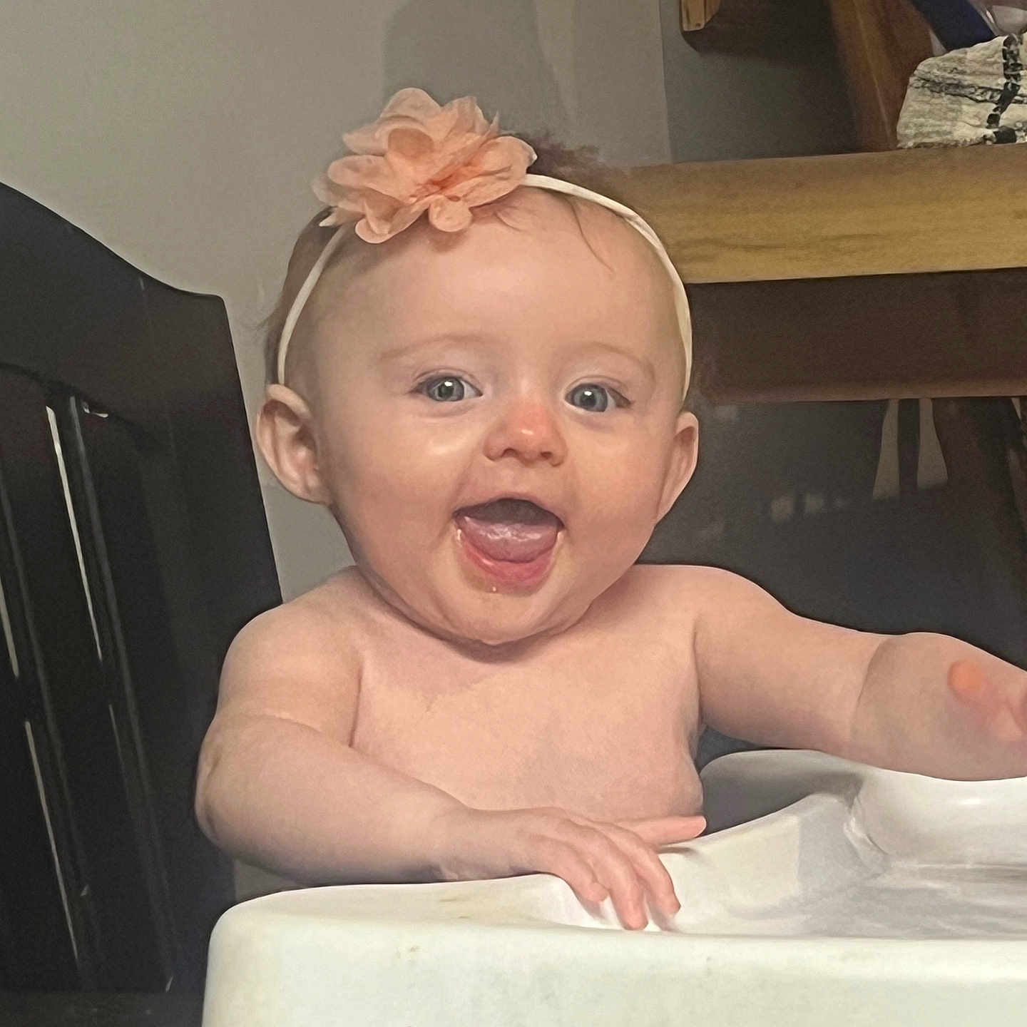 Maizy joined the competition — help win amazing prizes! arm, baby, child, cute, expression, face, flower, furniture, happy, headband, high_chair, indoor, infant, mouth_open, person, seat, skin, smiling, table, tongue