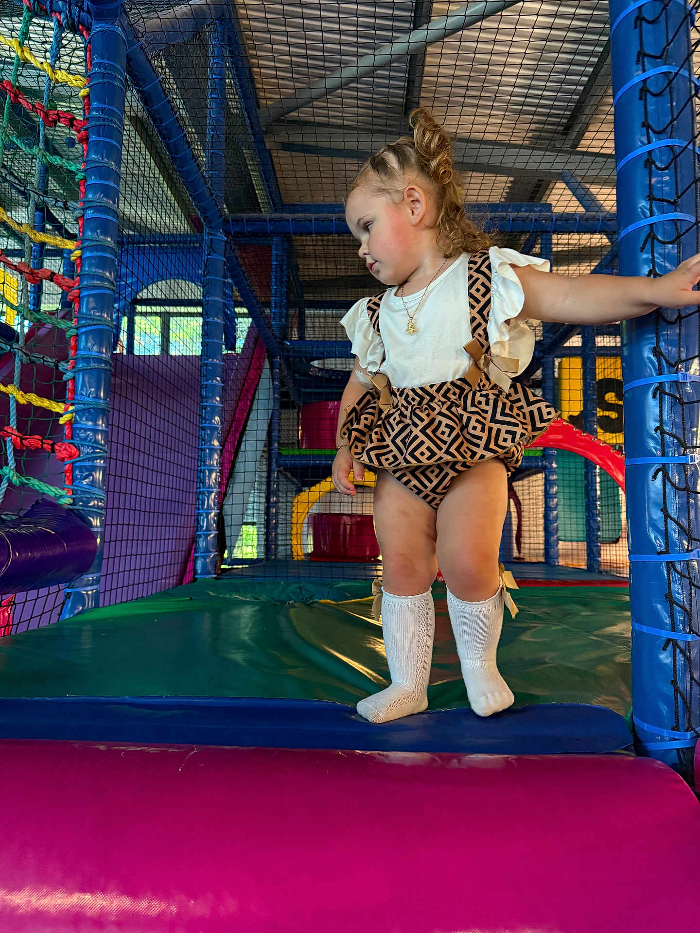 Darcie-Rae joined the competition — help win amazing prizes! toddler, child, indoor_play_area, netting, colorful, playground, romper, curly_hair, socks, soft_mats, netted_wall, play_structure, person, young_child, candid, casual_clothing, blue, pink, yellow, green