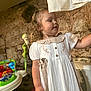 Darcie-Rae joined the competition — help win amazing prizes! toddler, girl, white_dress, curly_hair, indoor, stone_wall, toy, baby_toys, child, play_area, hand, furniture, curiosity, young_child, dress, person, room, household, cute, innocence