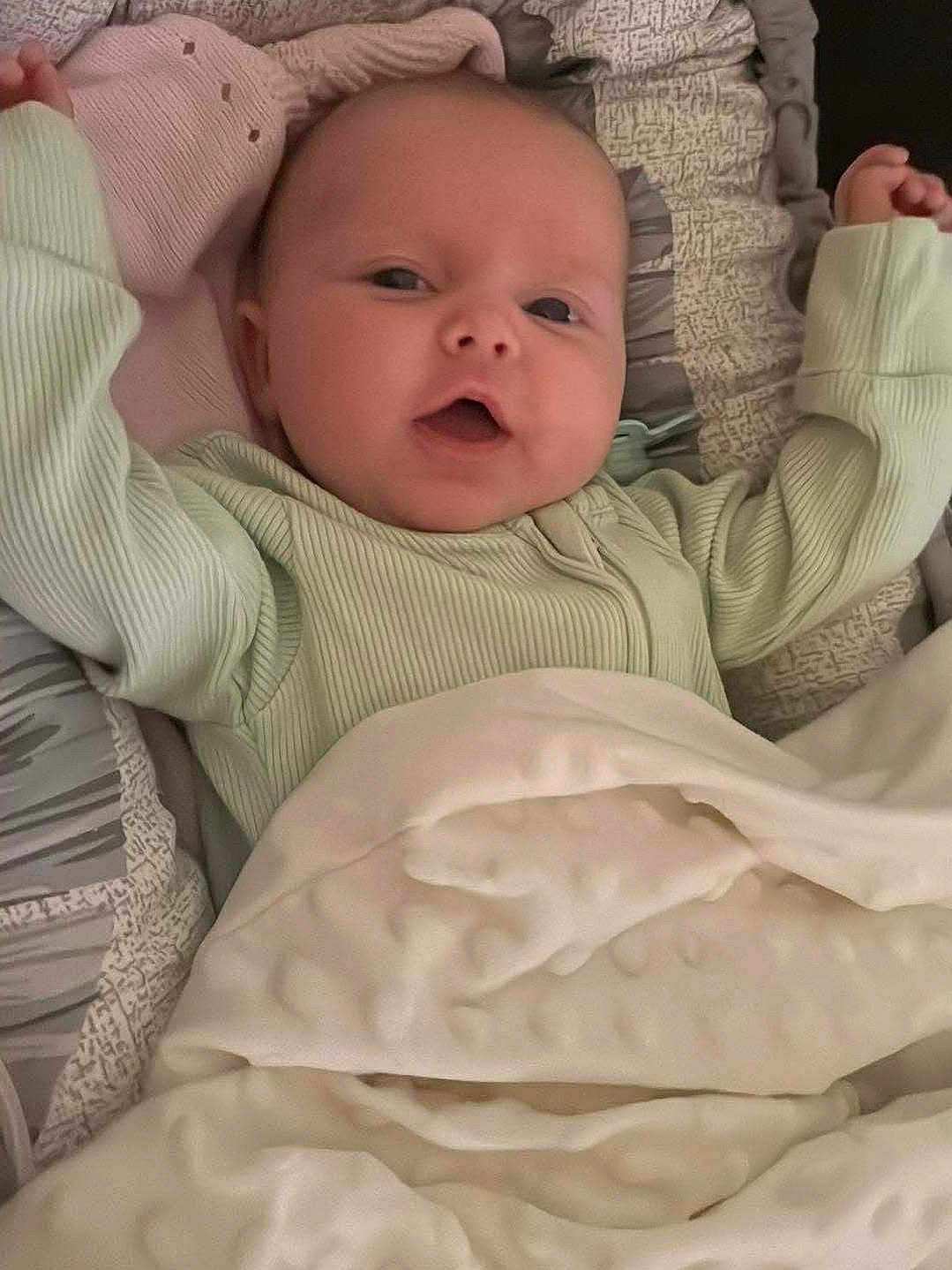 Amelia joined the competition — help win amazing prizes! baby, infant, blanket, bed, cozy, cute, face, clothing, comfort, expression, furniture, happy, indoors, infant_clothing, laying_down, person, portrait, sleeping_area, smiling, soft