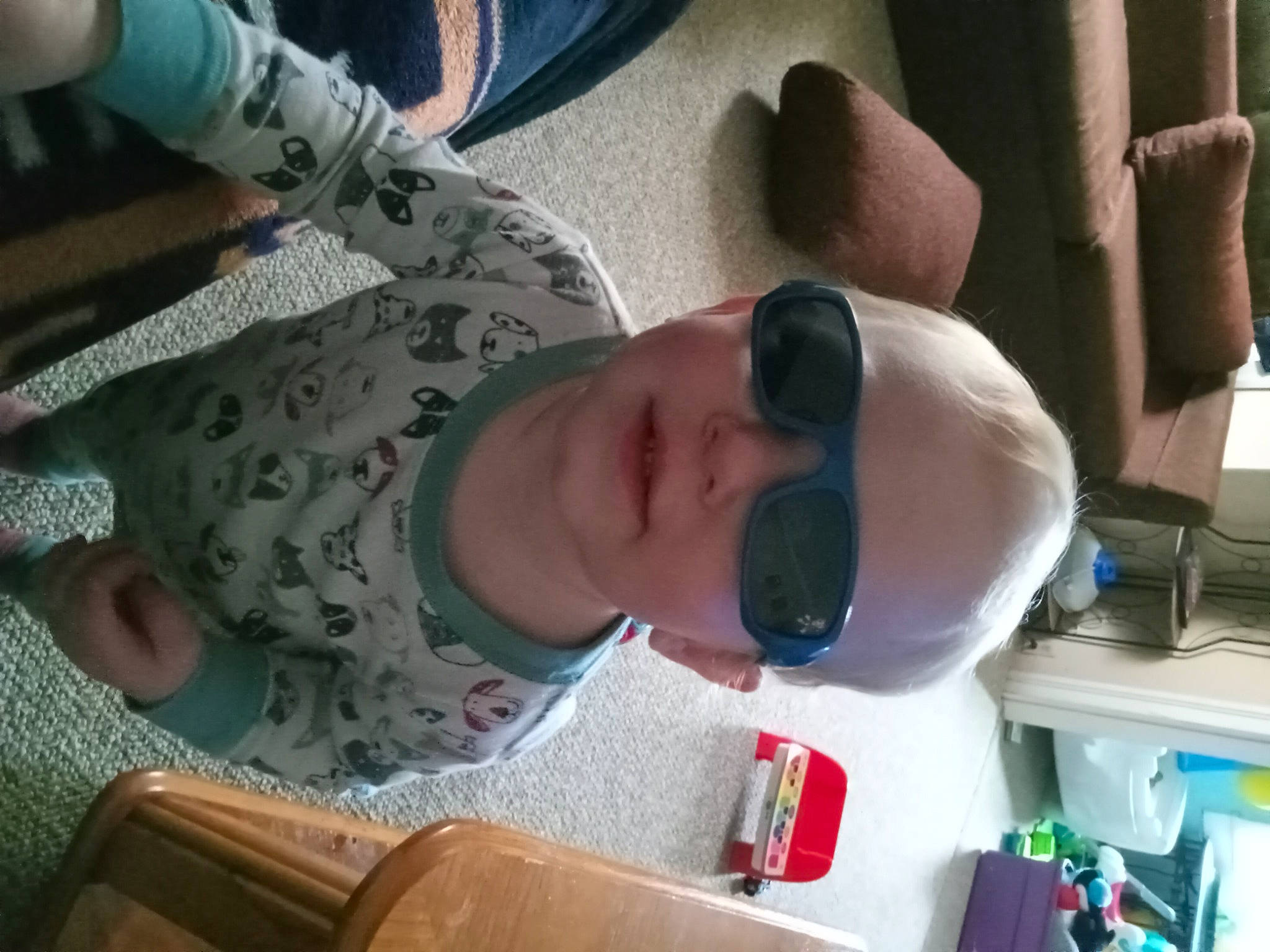 Dawson is registered to the contest to win money with this photo: baby, child, comfort, ear, eyewear, finger, fun, gesture, goggles, mouth, nail, nose, pattern, person, smile, sunglasses, thumb, toddler, vacation, vision_care