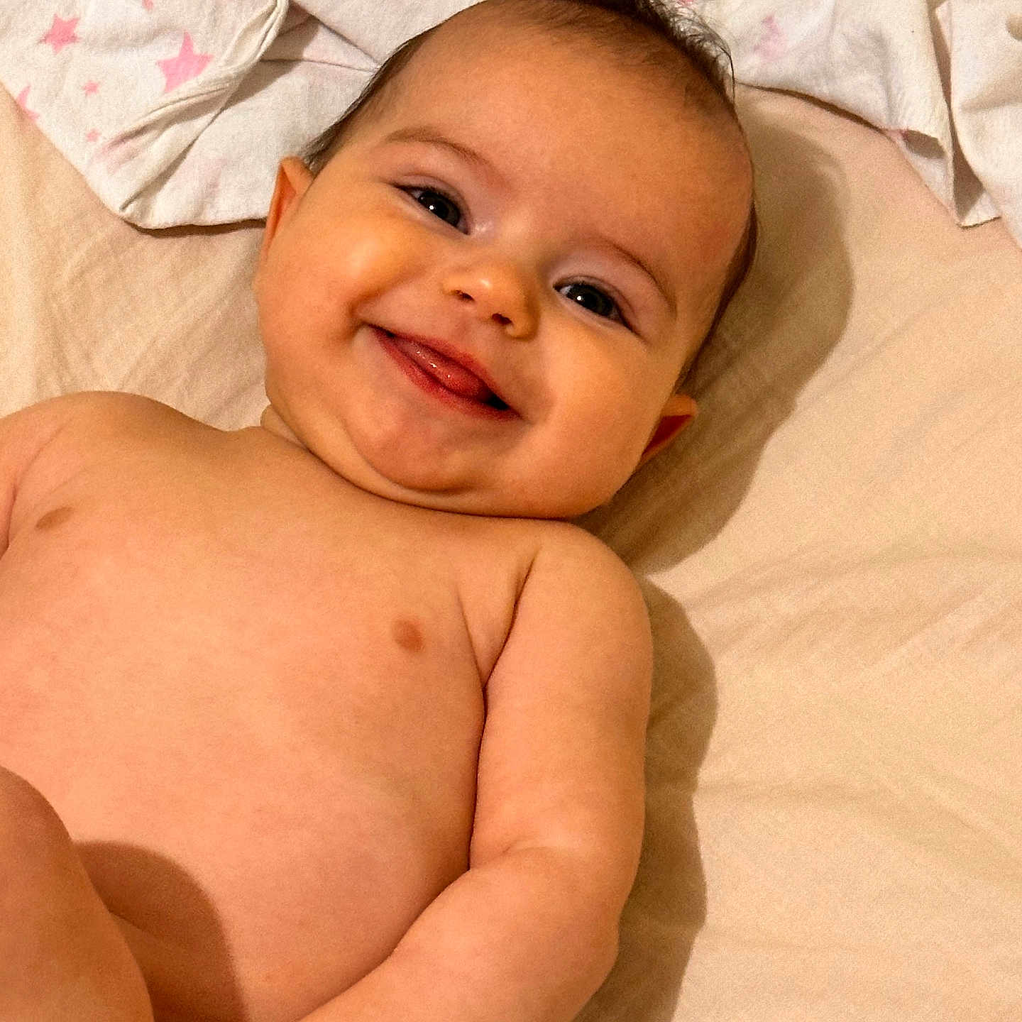 Sofia participe au concours pour gagner de l'argent avec cette photo : baby, bed, blanket, cheeks, child, comfort, cute, expression, face, hand, happy, indoors, infant, lying_down, person, skin, smiling, soft, tongue, young