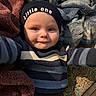 baby, child, infant, hat, clothing, striped_sweater, blanket, cozy, smile, face, person, indoor, cute, young, headwear, reaching_out, soft_texture, warm, happy, portrait