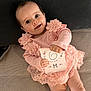 baby, card, child, closeup, couch, cute, fabric, happy, holding_object, indoor, infant, lace, person, pillow, pink_dress, portrait, sitting, six_months, smiling, young_child