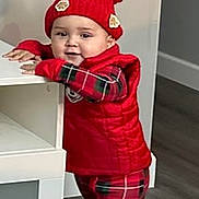 Thiago joined the competition — help win amazing prizes! toddler, child, red_hat, pajamas, red_vest, plaid, indoor, wood_floor, furniture, standing, cute, baby, smiling, winter_clothing, hat_with_pom_poms, home, person, young_child, playful, cozy