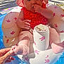 baby, infant, pool, inflatable, float, pink_hat, red_swimsuit, sunlight, grass, hand, water, summer, cute, outdoor, playful, child, sitting, foot, thumb, bunny_pattern