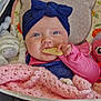 baby, infant, blue_eyes, headband, pink_clothing, blanket, biscuit, plush_toy, stroller, cushion, indoor, child, cute, hand, face, portrait, soft_toys, cozy, smiling, comfort
