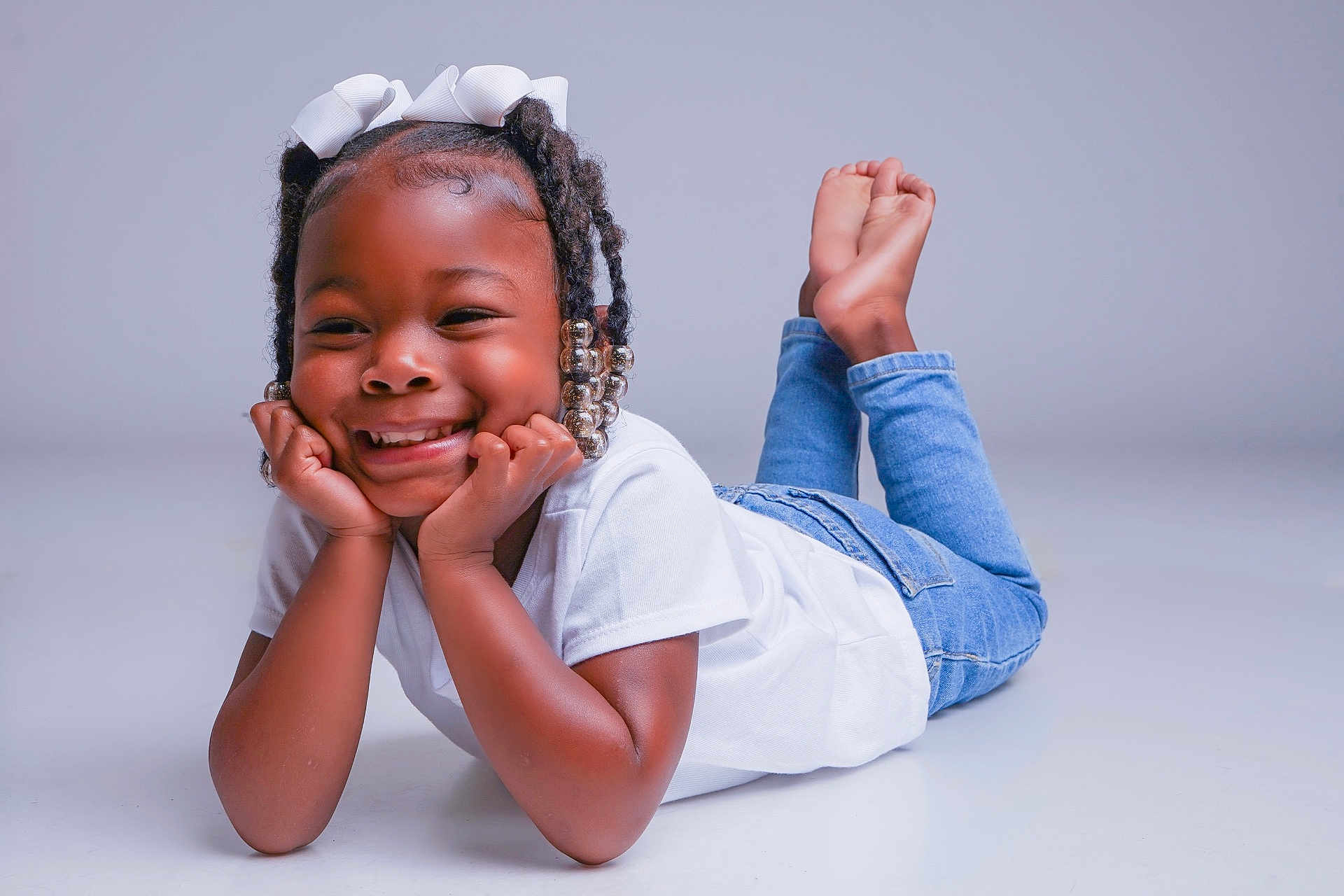 A'Layah joined the competition — help win amazing prizes! child, girl, smile, happy, braided_hair, white_bow, beads, white_tshirt, blue_jeans, posing, studio, portrait, feet_up, casual_clothing, cute, joyful, young, fashion, studio_lighting, innocence