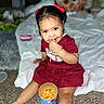 Sariyah is registered to the contest to win money with this photo: child, toddler, girl, sitting, bed, bedroom, red_dress, hair_bows, snack, cheese_puffs, eating, smiling, portrait, indoors, plush_toy, blanket, carpet, food, facial_expression, photography