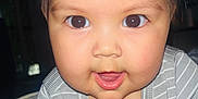 Sariyah is registered to the contest to win money with this photo: baby, child, closeup, curious, cute, expression, eyes, face, hair, indoors, infant, mouth, onesie, person, portrait, skin, smiling, soft_light, striped_clothing, young
