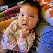 Sariyah is registered to the contest to win money with this photo: baby, infant, pajamas, sleepwear, blanket, pillow, resting, child, face, hand, comfort, indoor, portrait, cute, cozy, soft, expression, person, newborn, warm