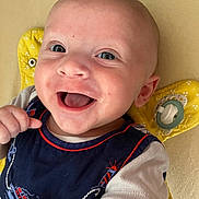 Lucas a rejoint le concours — aidez-le/la à gagner de superbes lots ! baby, smiling, happy, infant, face, blue_eyes, clothing, navy_blue, pacifier, yellow_cushion, lying_down, cute, child, skin, expression, mouth_open, hand, short_sleeves, indoors, portrait