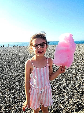 Swann a rejoint le concours — aidez-le/la à gagner de superbes lots ! baby_toddler_clothing, beach, cotton_candy, dress, eyewear, frozen_dessert, fun, gesture, glasses, goggles, happy, joy, people_in_nature, person, pink, sky, smile, summer, sunglasses, toddler