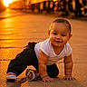 baby, child, crawling, outdoor, sunset, pavement, train, train_tracks, smiling, white_shirt, black_pants, red_shoes, happy, infant, young_child, golden_hour, warm_light, cute, portrait, sunlight