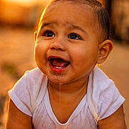 Armonii is registered to the contest to win money with this photo: baby, child, smiling, drool, white_shirt, close_up, cute, happy, portrait, infant, skin, face, eyes, mouth, head, outdoor, warm_light, expression, person, young