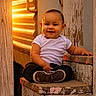 Armonii is registered to the contest to win money with this photo: baby, child, toddler, smiling, white_shirt, black_pants, sneakers, wooden_step, rustic, sunset_light, warm_light, outdoor, face, portrait, sitting, happy, expression, wood_texture, corrugated_metal, person
