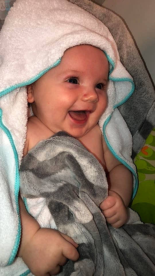 Kenai joined the competition — help win amazing prizes! baby, baby_toddler_clothing, blanket, bonnet, cheek, child, comfort, costume_accessory, eyebrow, facial_expression, headwear, iris, laugh, linens, mouth, nose, organ, person, pleased, skin