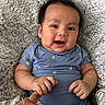 baby, infant, smiling, blue_onesie, hand_holding, blanket, fluffy, cute, face, portrait, happy, skin, person, child, baby_clothes, newborn, lying_down, fingers, close_up, soft_texture