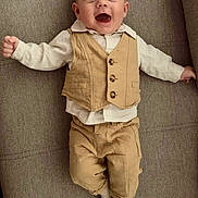 Aaron participe au concours pour gagner de l'argent avec cette photo : baby, child, smiling, vest, pants, white_shirt, socks, couch, fabric, portrait, happy, infant, cute, indoor, person, clothing, texture, face, lying_down, joy