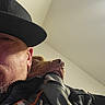 Goose joined the competition — help win amazing prizes! man, dog, hat, jacket, close_up, selfie, indoor, face, pet, companion, resting, cozy, casual, relaxed, portrait, human, animal, friendship, indoor_lighting, warmth