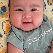 Jireh is registered to the contest to win money with this photo: baby, smiling, infant, calvin_klein, cute, chubby_cheeks, clothing, blanket, animal_print, happy, child, portrait, young, lying_down, indoors, soft_lighting, closeup, face, skin, hand