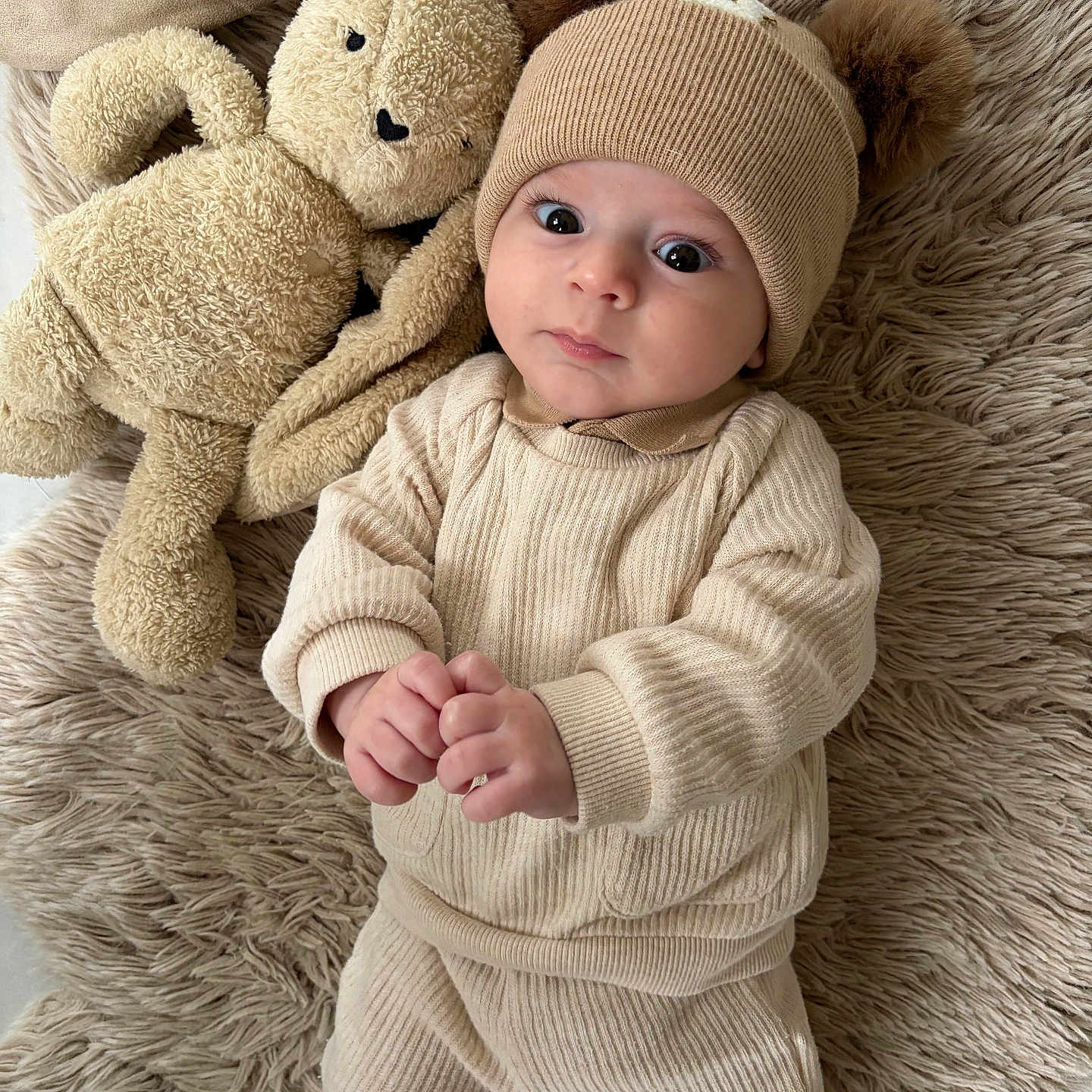Harry participe au concours pour gagner de l'argent avec cette photo : adorable, baby, beige, bunny, child, clothing, cozy, cute, expression, hands, hat, indoor, infant, knitwear, lying_down, plush_toy, portrait, rug, soft_texture, stuffed_animal