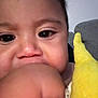 Asher joined the competition — help win amazing prizes! baby, close_up, face, hand, chewing, plush_toy, yellow, couch, indoor, child, cute, skin, person, infant, expression, portrait, young, soft_toy, furniture, childhood