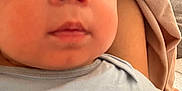 Asher is registered to the contest to win money with this photo: baby, close_up, face, infant, child, blue_clothing, blanket, couch, skin, eyes, cheeks, expression, curious, indoors, person, soft_texture, young, portrait, snuggle, cozy